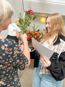 Übergabe von Zeugnis und Rose an eine Absolventin.