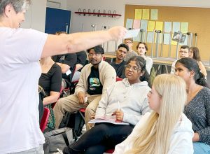 Frau Berninger verteilt Karten an Auszubildende am Begrüßungstag.