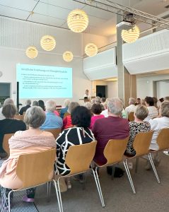 Teilnehmer der Vortrages hören Dr. Elisabeth van Elten bei ihrer Präsentation zu.