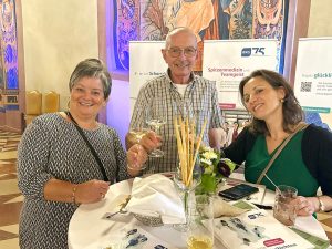 Ursula Berninger, Eugen Reifenscheid und Emanuela Gattari stoßen mit einem Weinglas im Kaisersaal an.