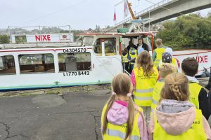 Herr Jürgen Chodera von der Klinik Kitzinger Land lädt die Kindergruppe auf das Boot Namens Nixe ein.