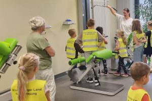 Die Kinder betrachten in der Physiotherapie-Abteilung die Trainingsgeräte.