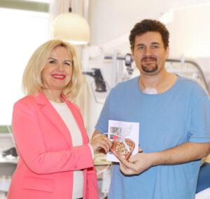 Die Landrätin überreicht Steven Cox ein Lebkuchenherz.