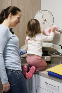 Dr. Katharina Domdey mit ihrer Tochter an der Babywaage im Kreißsaal der Klinik Kitzinger Land.