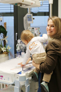 Dr. Monika Wegmann mit ihrem Kind auf dem Arm an der Versorgungsstation für Neugeborene.