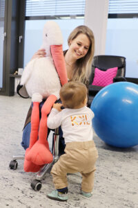 Dr. Monika Wegmann hält einen großen Storch aus Plüsch in der Hand, ihr Sohn steht vor ihr.