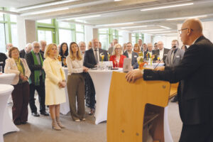 Dr. Pfeiffle hält vor vielen Gästen an Stehtischen eine Rede.