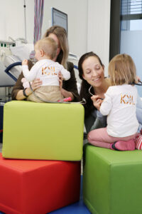 Dr. Monika Wegmann und Dr. Katharina Domdey spielen mit ihren Kindern im Kreißsaal der Klinik Kitzinger Land auf bunten Würfeln.