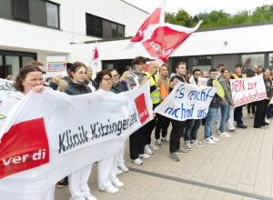 Protestgruppe vor der Klinik Kitzinger Land mit Bannern und Fahnen.