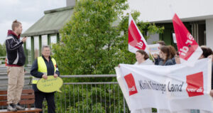 ver.di Mitarbeiter hält eine Rede vor Klinikmitarbeitern.